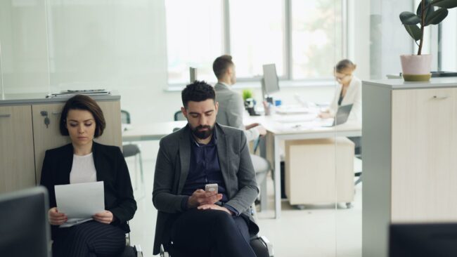 Two people waiting in an office lobby